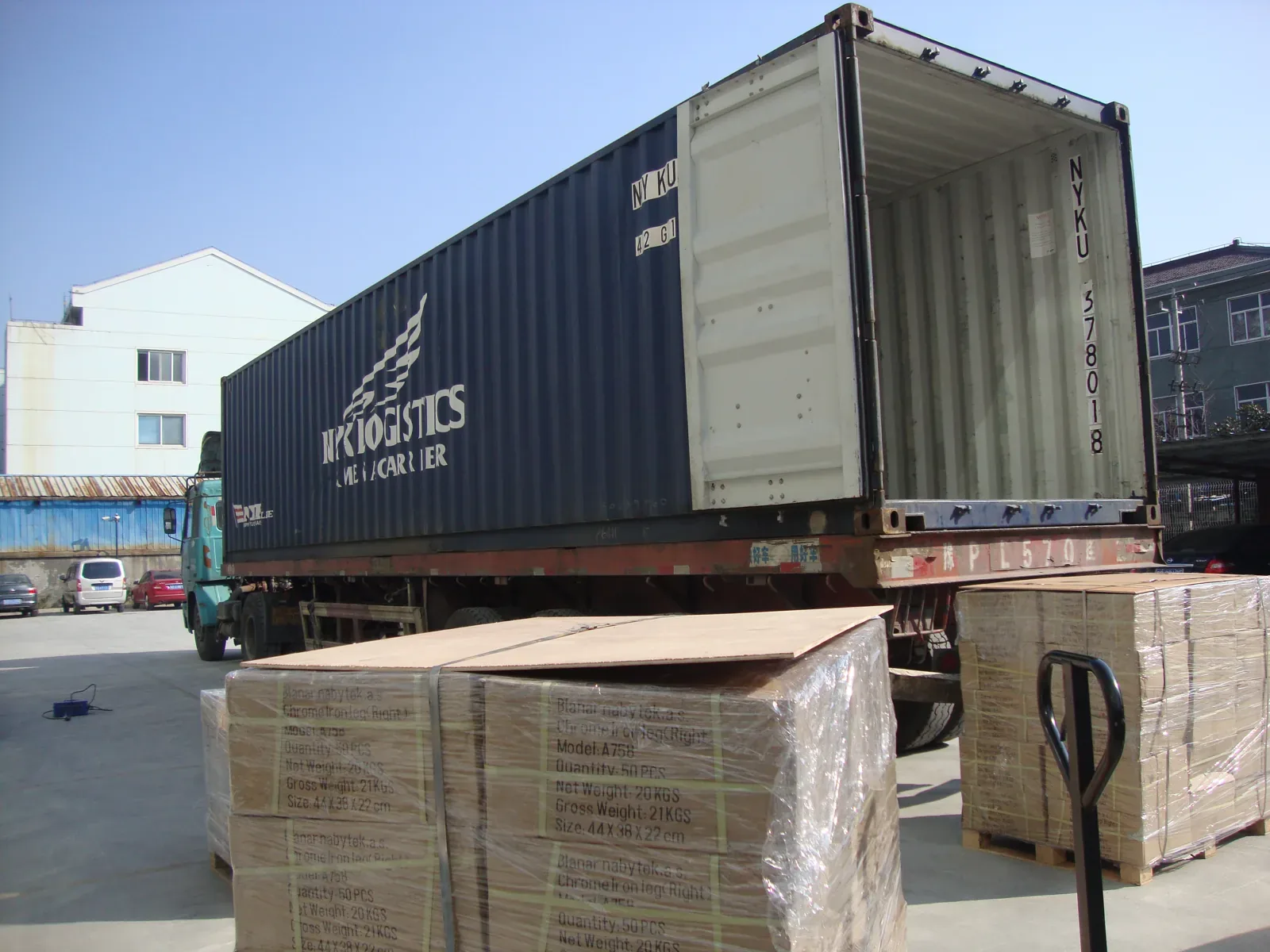 Export cartons staged beside a shipping container