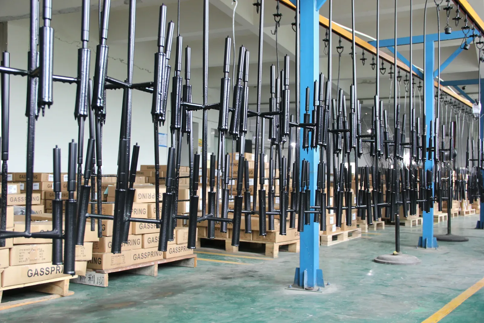 Coated gas spring tubes hanging on racks after the coating line