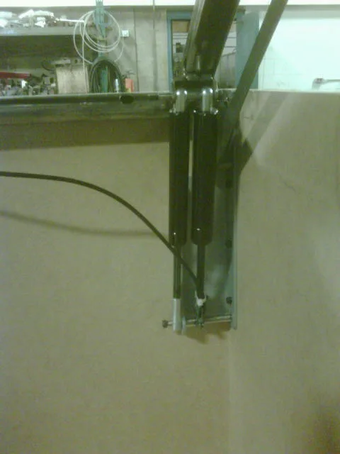 Gas struts supporting an industrial machine access panel